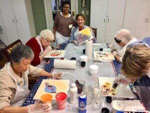 Houston artist Tasnuva Rahman posing with a student while teaching an art class for elderly residents at Brookdale Retirement in Tomball, TX