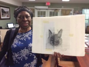 A resident at Brookdale Retirement in Tomball, TX presents her finished project. Houston artist Tasnuva Rahman gives back to the community by teaching an art class.