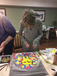 An elderly resident at Brookdale Retirement in Tomball, TX working on her art project. Houston artist Tasnuva Rahman gives back to the community by teaching an art class.