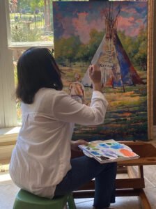 Houston artist Tasnuva Rahman working on a commissioned portrait of a traveling memory for Mrs. Peacock.